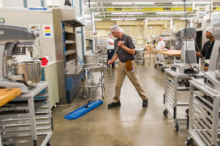 Man sweeping the floor of a food facility