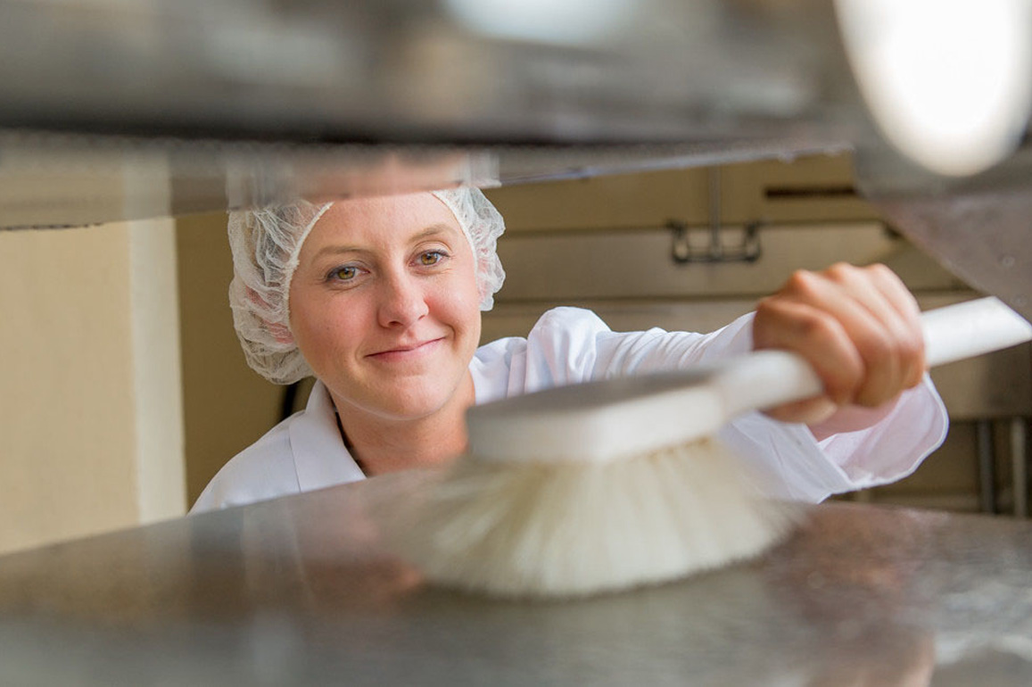 Woman using a brush to clean equipment